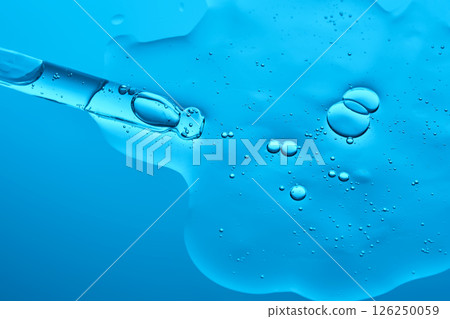 Hydrolyzed sponge serum with a pipette on a blue background. 126250059