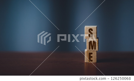 Stacked Wooden Cubes Spelling SME on a Dark Toned Table with Blurred Background Stacked Wooden Cubes Spelling SME on a Dark Toned Table with Blurred Background 126250068