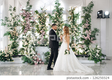 Beautiful and in love newlyweds dance in a banquet hall 126250324