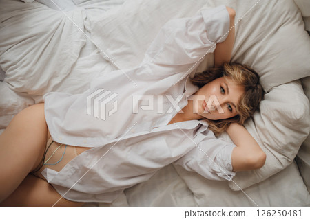 sexy woman in white shirt in bed. female attractiveness and sexuality. top view 126250481