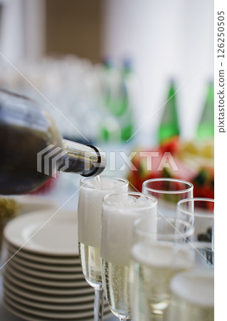 close-up. Champagne from the bottle is poured into glasses on the buffet table.  126250505