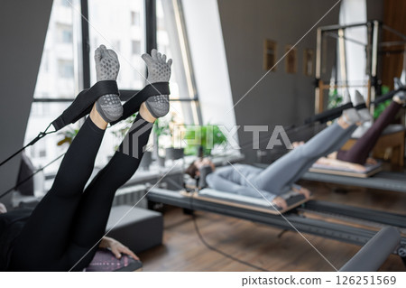 A detailed closeup of a foot work and core exercise on a Balanced Body Reformer machine illuminated by sunlight 126251569