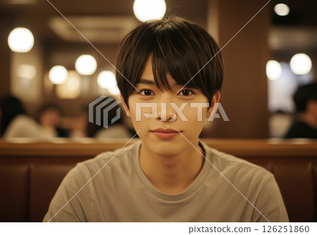 咖啡館裡一位年輕男子對著鏡頭微笑的肖像（AI 生成的圖像） 126251860