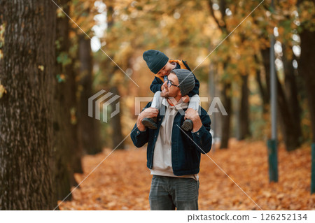 Cheerful mood. Father and young son is together outdoors at daytime Cheerful mood. Father and young son is together outdoors at daytime 126252134