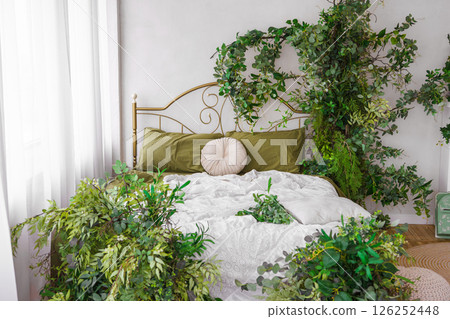 Cozy bedroom adorned with lush greenery and natural spring decor for tranquil atmosphere 126252448