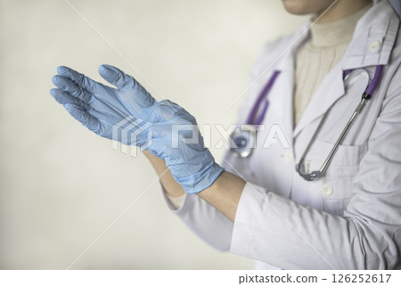 woman doctor wears medical gloves woman doctor wears medical gloves 126252617