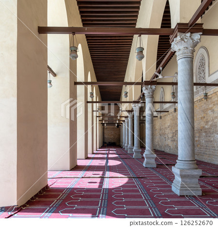 Historic mosque of al-Zahir Baybars features intricate columns and a vibrant prayer carpet in Cairo, Egypt 126252670