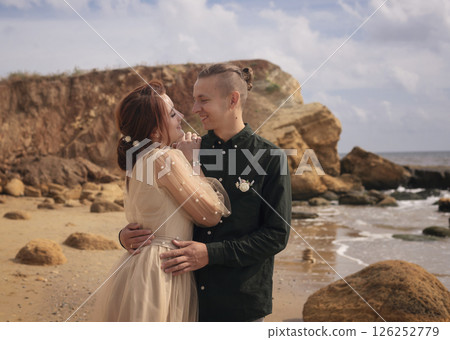 a couple of lovers are standing on the seashore 126252779
