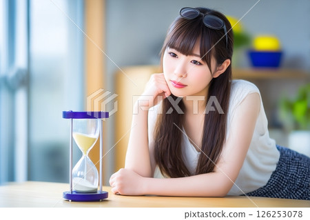 女孩盯著沙漏裡掉下來的沙子 126253078