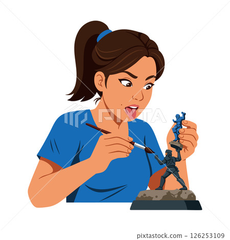Young woman painting miniature figurines hobby creative activity in blue shirt 126253109