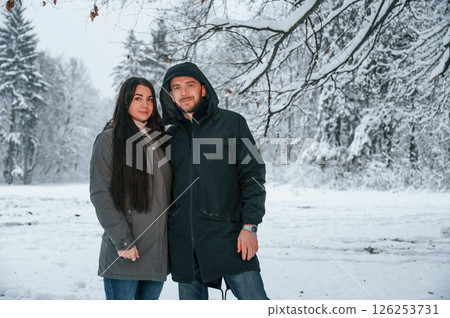 Couple is standing together in the winter forest 126253731