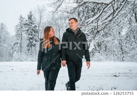 Couple is in the winter forest, having a walk 126253755