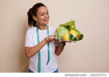 Portrait of a Smiling Woman Holding Healthy Fresh Fruits and Vegetables for Wellness Portrait of a Smiling Woman Holding Healthy Fresh Fruits and Vegetables for Wellness 126253772