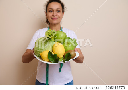 Portrait of a Woman Holding a Plate of Fresh Fruits and Vegetables Promoting Wellness Portrait of a Woman Holding a Plate of Fresh Fruits and Vegetables Promoting Wellness 126253773