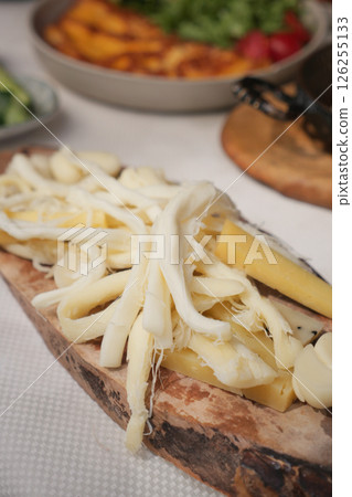 Delicious assortment of cheeses served on wooden board at dinner 126255133