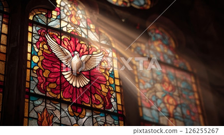 Stained glass window with dove and sunbeams in sacred church setting. 126255267