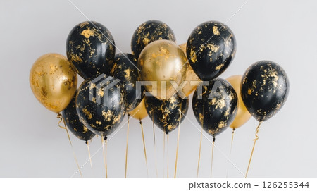 Elegant black and gold balloons with metallic accents on gray background. 126255344