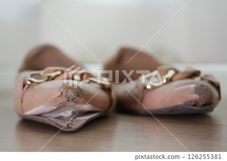 closeup of damage shoes on wooden floor  126255381