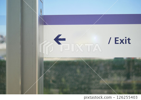 Sign directing to left exit at a transportation station 126255403