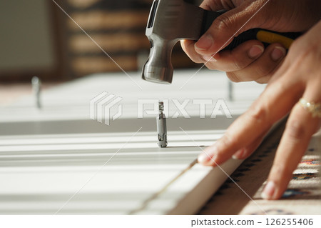 Hammering nails into wood for home improvement project Hammering nails into wood for home improvement project 126255406