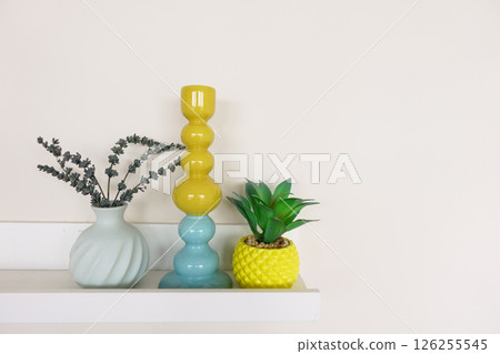 Colorful home decor arrangement on a shelf in a modern interior 126255545