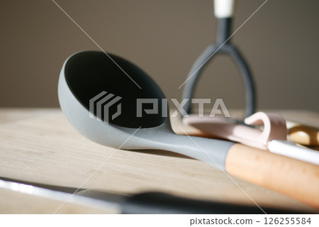 Kitchen utensils arranged on a wooden surface in soft lighting Kitchen utensils arranged on a wooden surface in soft lighting 126255584