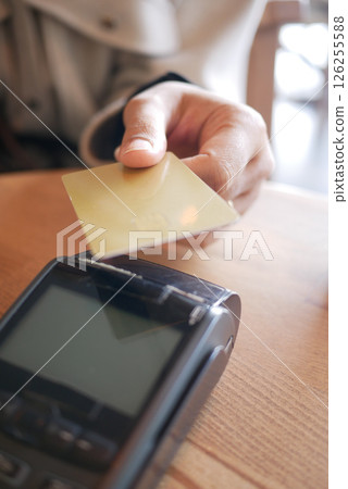 Customer making a payment with card at a cafe in the morning Customer making a payment with card at a cafe in the morning 126255588