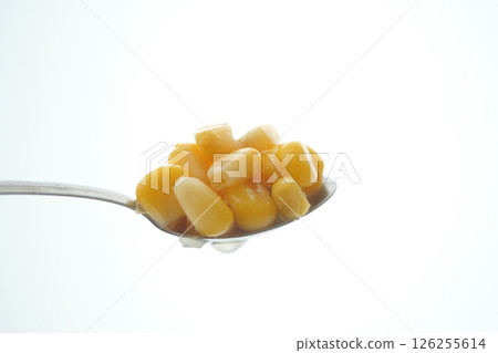 Close-up of corn kernels on a spoon against a bright background Close-up of corn kernels on a spoon against a bright background 126255614