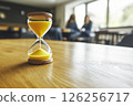 Yellow Sand Running through Hourglass Measuring Time in a Calm Modern Environment 126256717