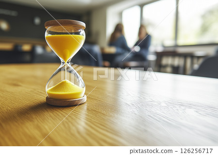 Yellow Sand Running through Hourglass Measuring Time in a Calm Modern Environment 126256717