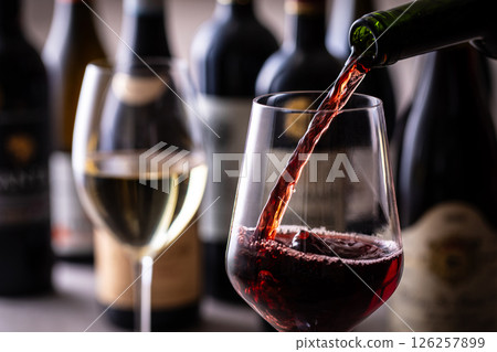 Pouring red wine into a wine glass Pouring red wine into a wine glass 126257899