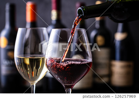Pouring red wine into a wine glass Pouring red wine into a wine glass 126257969