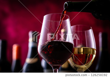 Pouring red wine into a wine glass Pouring red wine into a wine glass 126258192