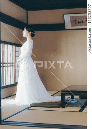 Profile portrait of a woman in a wedding dress standing in a Japanese-style room Profile portrait of a woman in a wedding dress standing in a Japanese-style room 126258297
