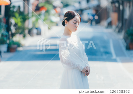 一位身穿婚紗的女子站在傳統街道上的肖像 126258362