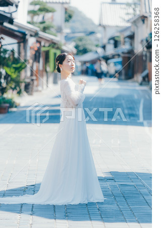 一位身穿婚紗的女子站在傳統街道上的肖像 一位身穿婚紗的女子站在傳統街道上的肖像 126258368