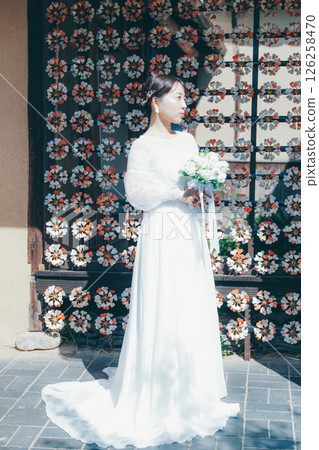 身著婚紗的女子肖像，背景為日式花卉裝飾 126258470