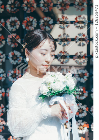身著婚紗的女子肖像，背景為日式花卉裝飾 126258473