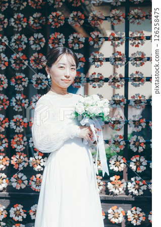 身著婚紗的女子肖像，背景為日式花卉裝飾 126258475