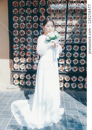 身著婚紗的女子肖像，背景為日式花卉裝飾 126258477