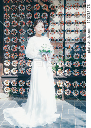 身著婚紗的女子肖像，背景為日式花卉裝飾 126258478