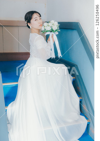 一位身穿婚紗的女子坐在樓梯上回頭看的肖像 一位身穿婚紗的女子坐在樓梯上回頭看的肖像 126258496