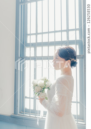 身穿白色洋裝的女子站在窗邊的剪影式肖像 身穿白色洋裝的女子站在窗邊的剪影式肖像 126258530