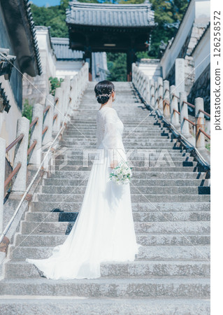 一位穿著婚紗的女子站在石階上 126258572