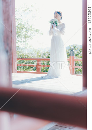 一位身著婚紗的女子從山上的神社俯瞰小鎮的畫像 一位身著婚紗的女子從山上的神社俯瞰小鎮的畫像 126258614