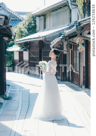 一位身穿白色婚紗的女子回望老城區的肖像 126258638