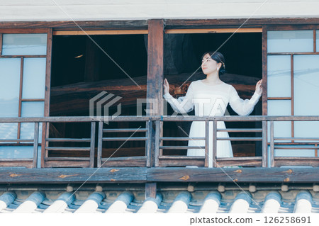一位身著婚紗的女子從聯排別墅的二樓向外望去 126258691