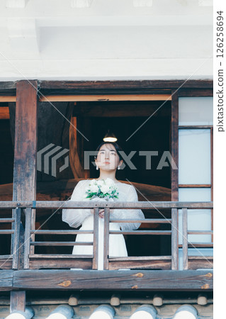 一位身著婚紗的女子從聯排別墅的二樓向外望去 126258694