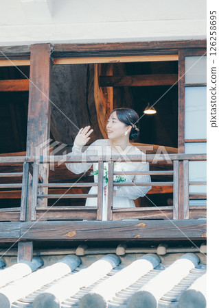 一位身著婚紗的女子從聯排別墅的二樓向外望去 一位身著婚紗的女子從聯排別墅的二樓向外望去 126258695