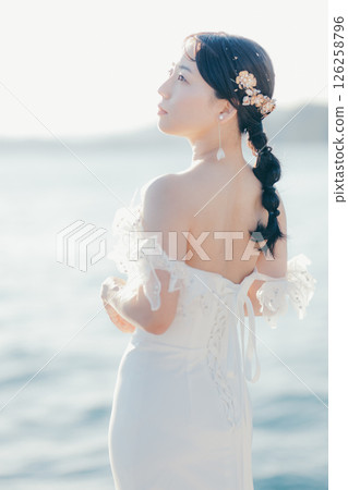 身穿婚紗的女子站在海灘背光下的肖像 身穿婚紗的女子站在海灘背光下的肖像 126258796